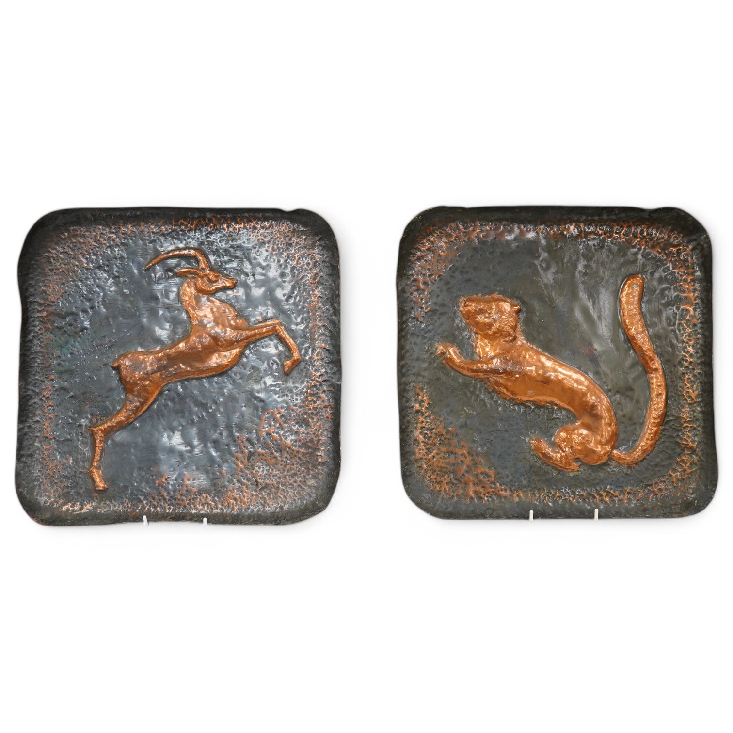 A pair of planished copper trays, one of an Impala and the other a Lion. 39.5cm square. Condition - fair